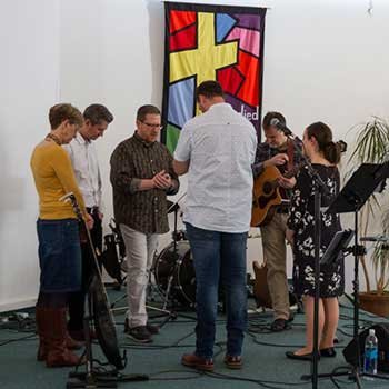 A pulpit in a church, with people praying