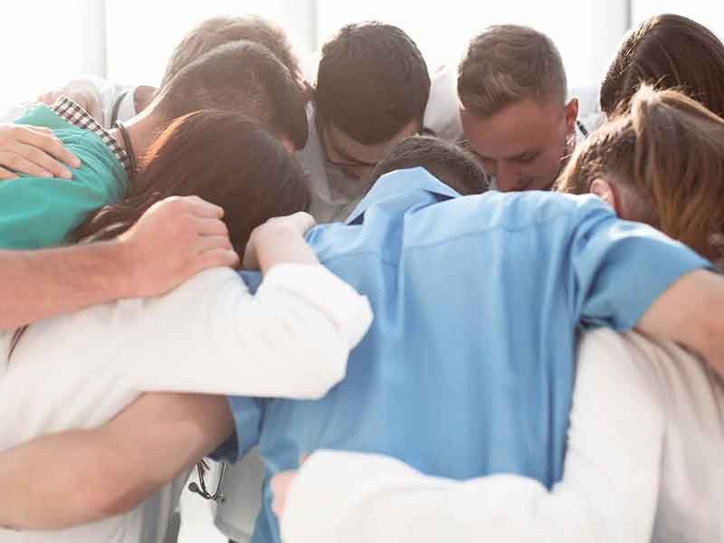 People huddled together and praying